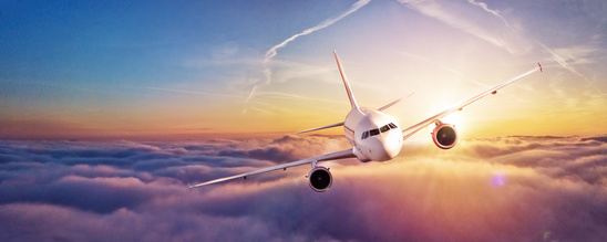 Commercial Airplane Flying Above Clouds